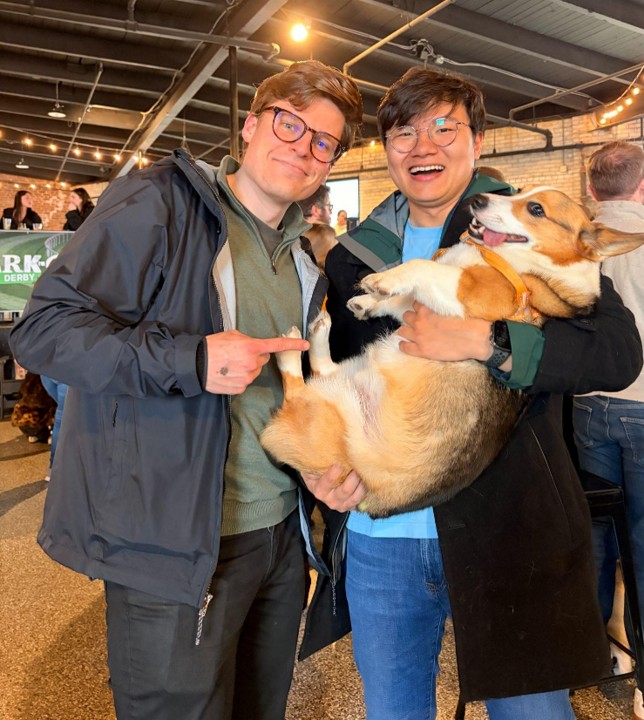 CaniBrush team members holding a corgi at the Park-9 Dog Bar event